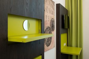 The appealing cabinet finish in a dark coloured, easily maintained wood look is accented with bright spring green sections, which are used as fold-out elements featuring catches made by Häfele.